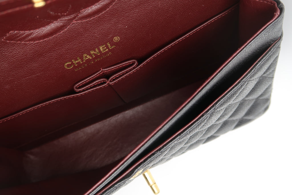 Interior of Chanel Classic Flap in black caviar showing burgundy leather lining and stamp