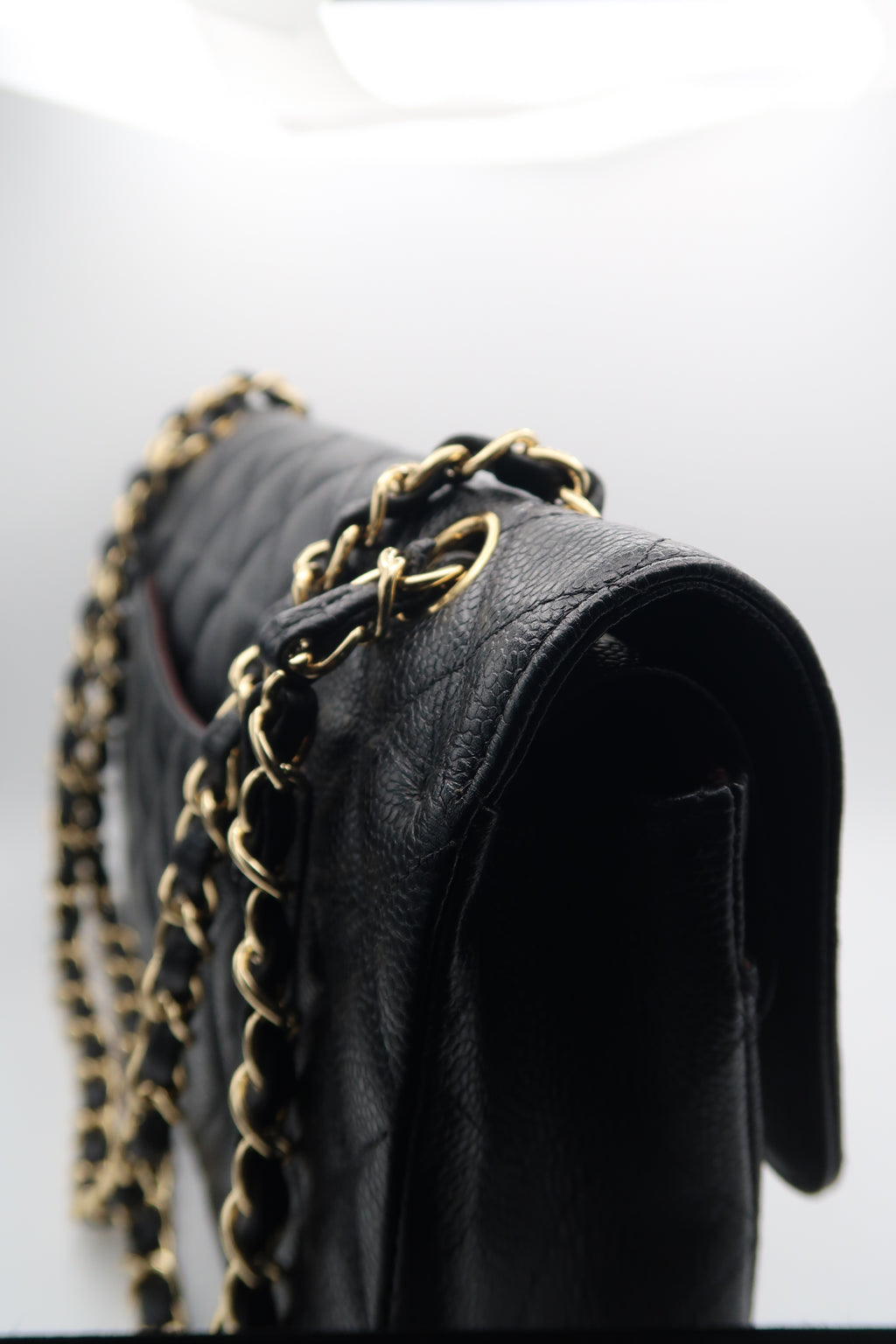 right side view of Chanel Classic Flap in black caviar