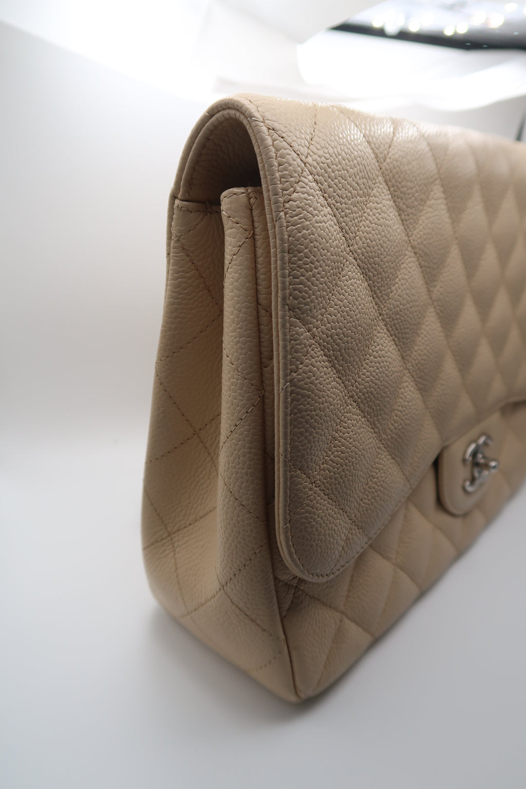 right side view of Chanel Classic Jumbo in beige caviar