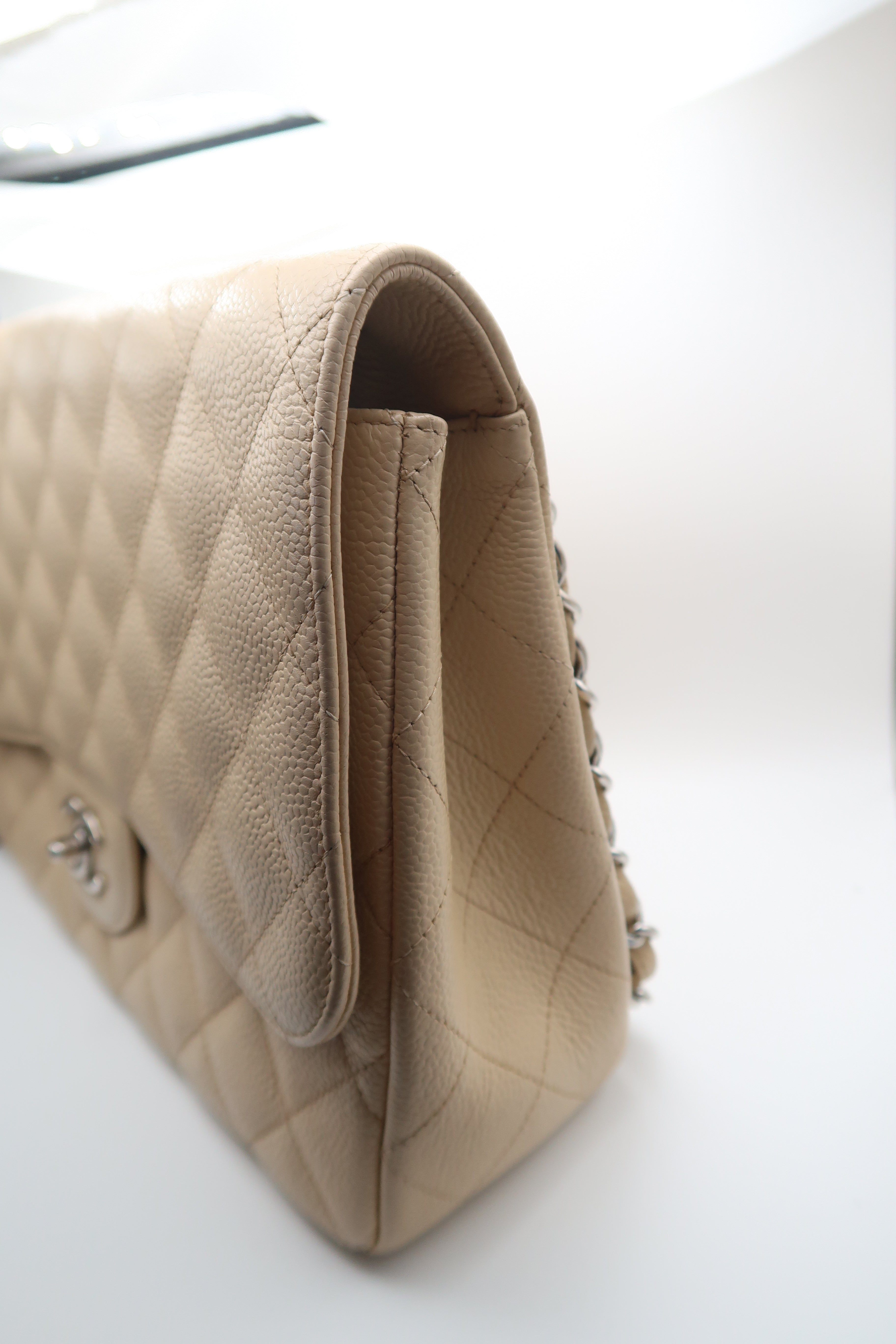 left side view of Chanel Classic Jumbo in beige caviar