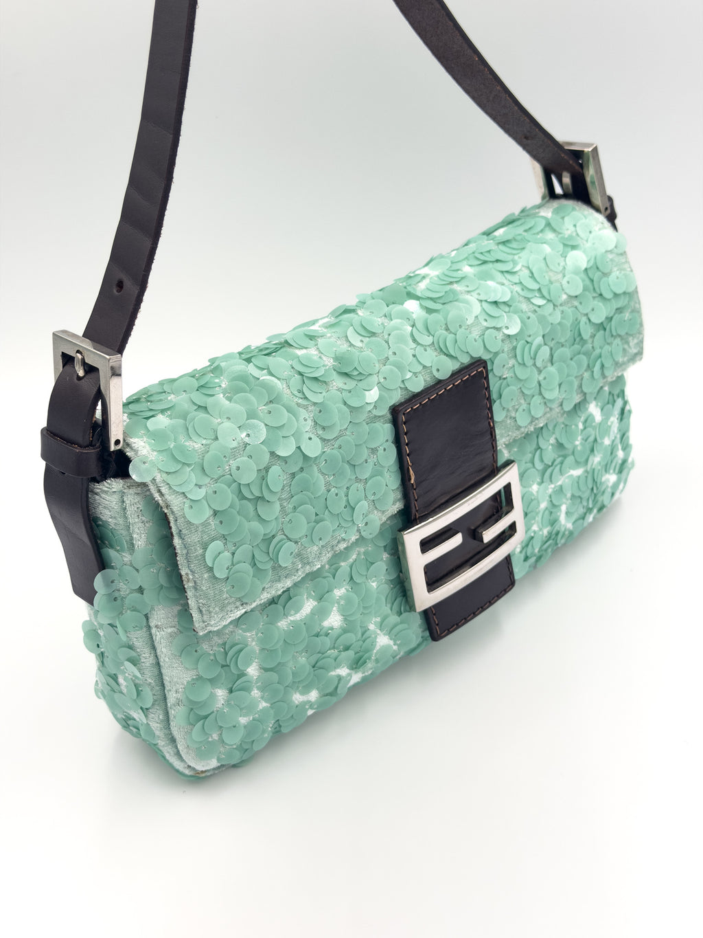 A mint green sequined shoulder bag with black leather trim and strap, featuring a silver-tone Fendi FF logo buckle on the front flap.