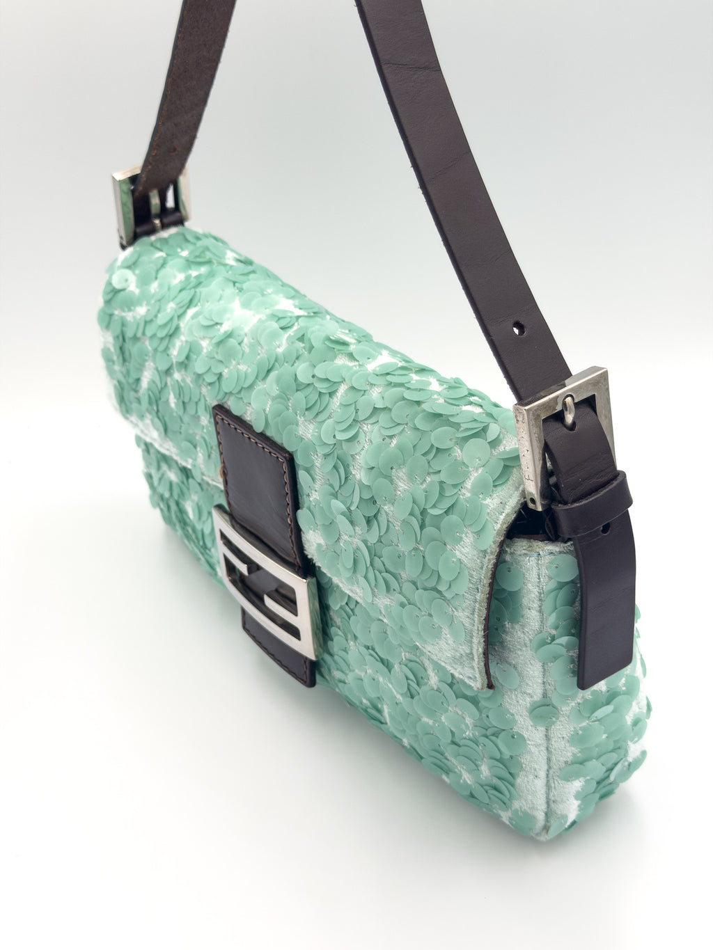 A mint green textured shoulder bag with dark brown leather straps and silver-tone hardware, shown on a clean white background.