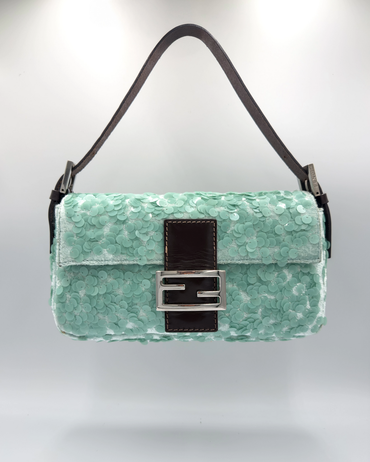 A mint green sequined Fendi shoulder bag with a dark brown leather strap and a silver-tone FF logo clasp, shown against a light gray background.